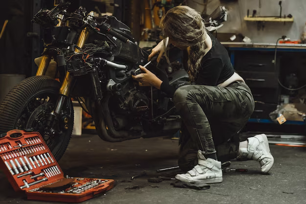 Mädchen repariert ein Motorrad in einer Werkstatt