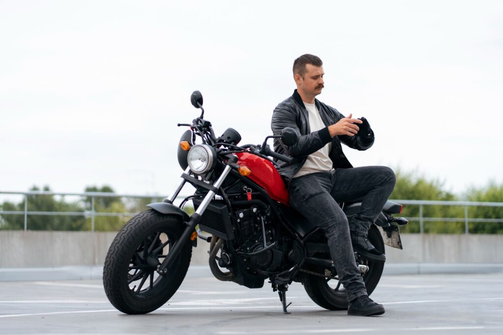 Mann mit Motorrad im Freien