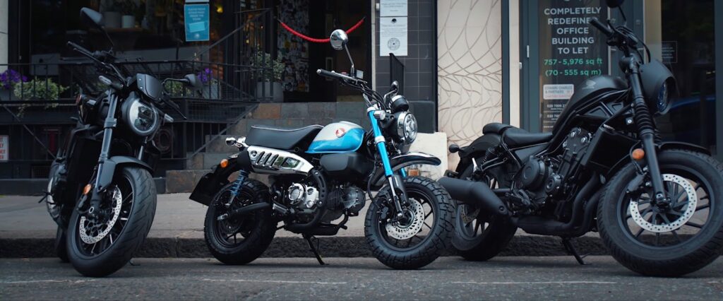Honda Monkey 125 Motorrad neben anderen Motorrädern