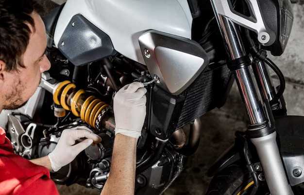 Ein Mann repariert den Seitenschutz eines Motorrads
