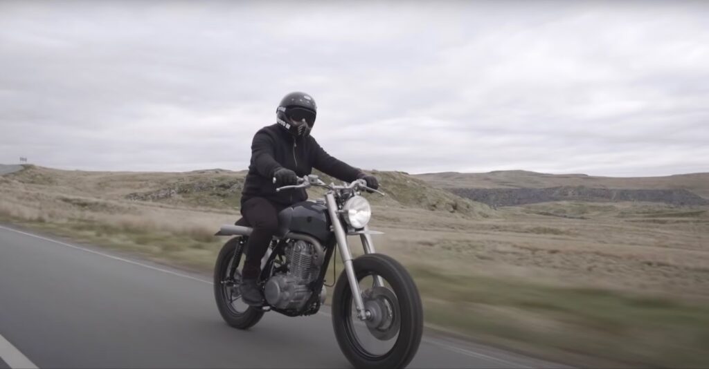 Ein Mann fährt mit einem Yamaha SR 500 Motorrad auf der Straße